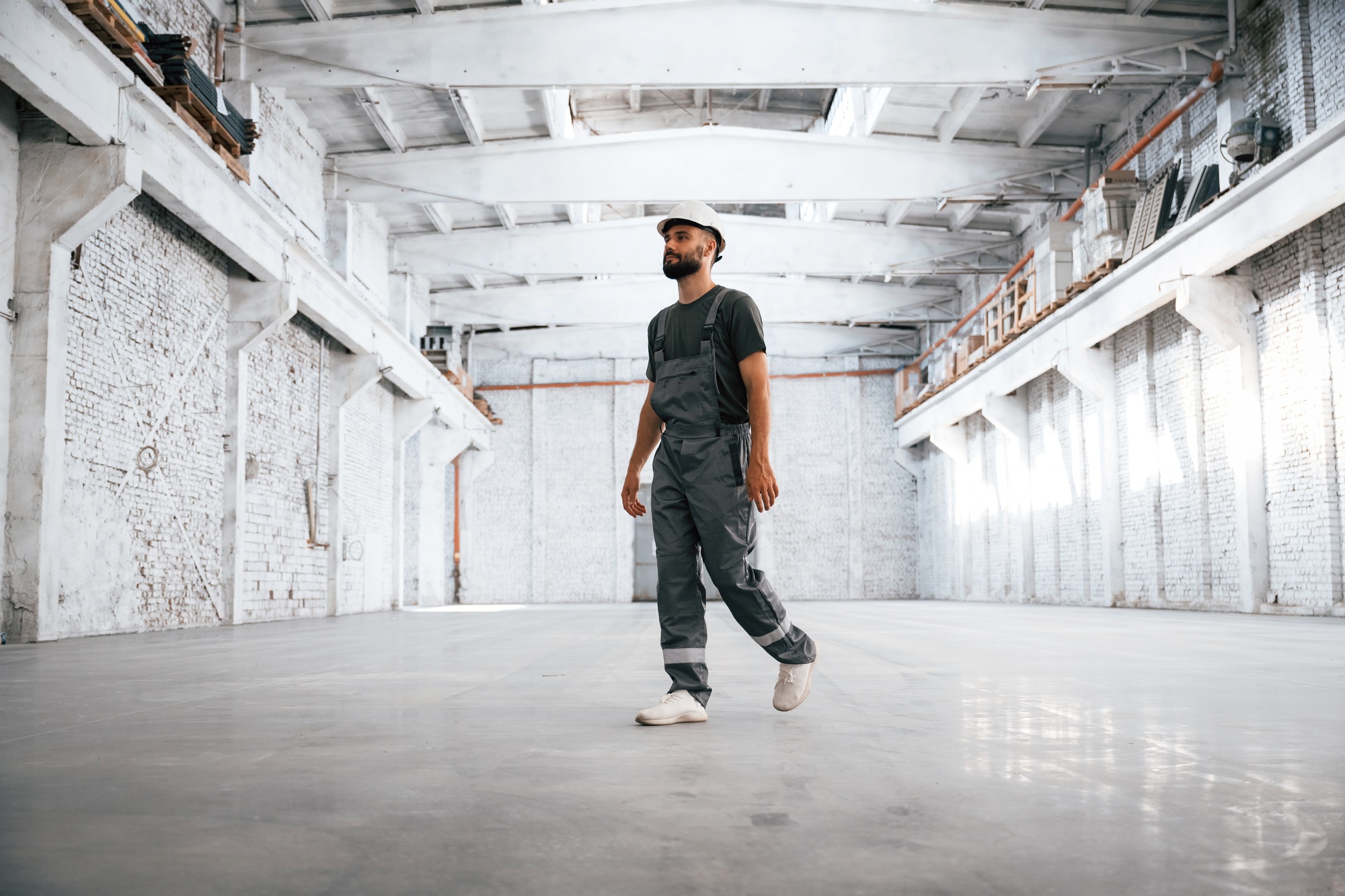Painted in white. Male worker is in the empty warehouse